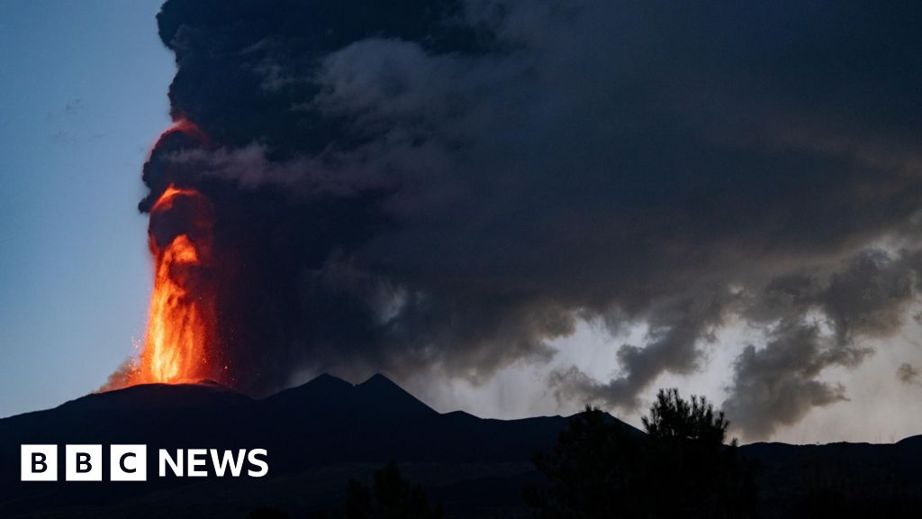 Mount Etna spits lava and smoke at dawn